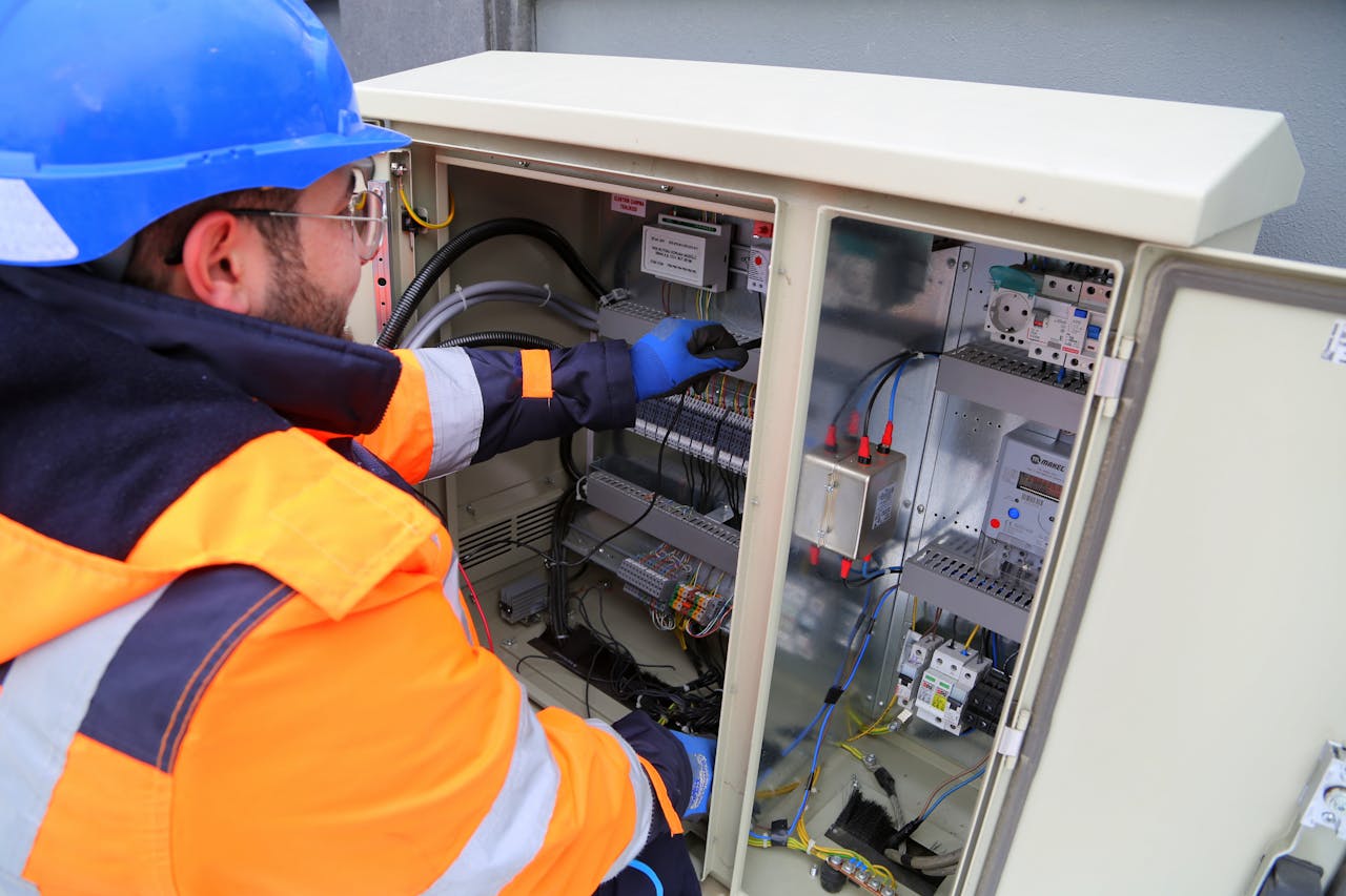 The Art of Drawing Readers In: Your attractive post title goes here Engineer in safety gear working on an outdoor electrical panel, ensuring system functionality.